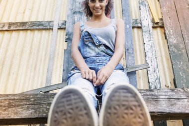 onun ayak foregroun ile parkta oturan genç güzel kız