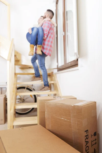 Young man holding his girlfriend in his arms after moving — Stock Photo, Image