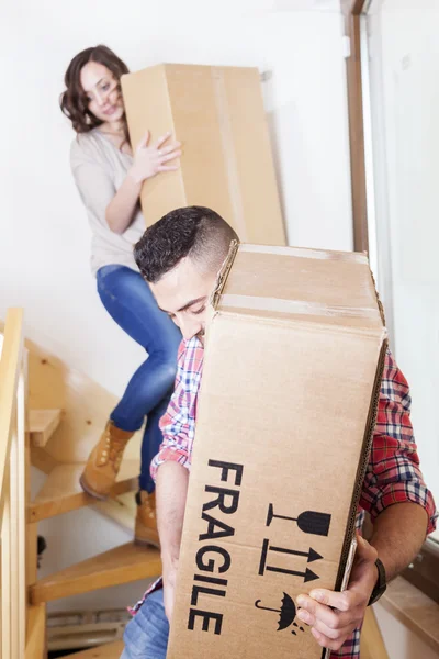 Jovem casal carregando as caixas em casa nova — Fotografia de Stock