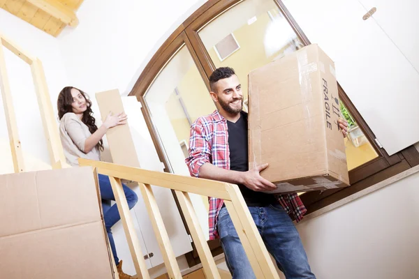 Young couple carrying the boxes in new house — Stock Photo, Image