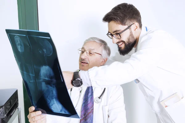 Médicos que examinan una radiografía del cuerpo de una mujer — Foto de Stock
