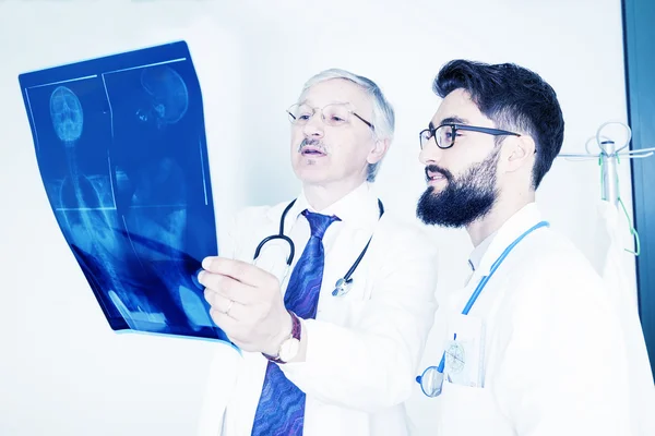 Couple of doctors examining an x-ray of a woman's body — Stock Photo, Image