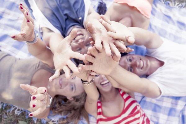 Liegende Gruppe junger Erwachsener drückt die Hände in die Höhe — Stockfoto