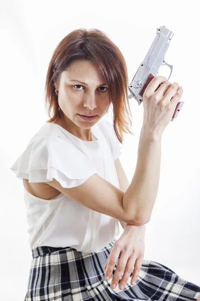 Sexig kvinna poserar med pistol på vit bakgrund — Stockfoto