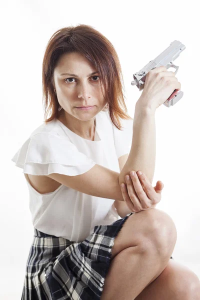 Sexig kvinna poserar med pistol på vit bakgrund — Stockfoto