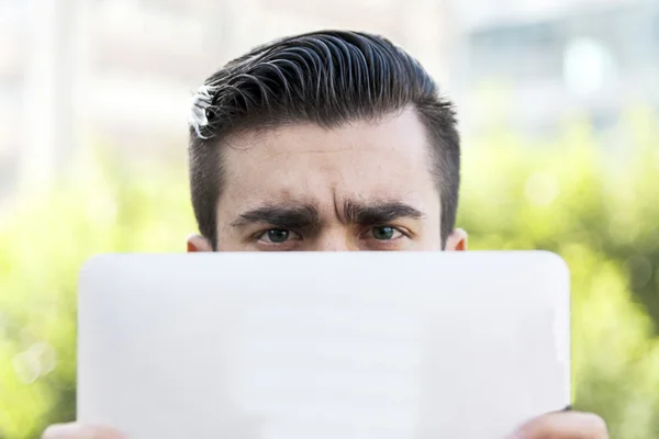 Unga hipster affärsman hålla den bärbara datorn framför ansikte — Stockfoto