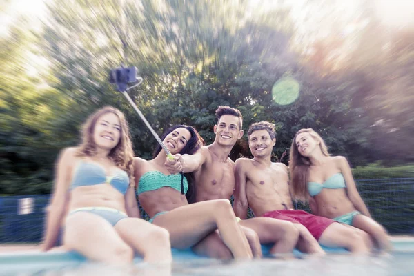 Skupina mladých přátel, přičemž selfie sedí u bazénu — Stock fotografie