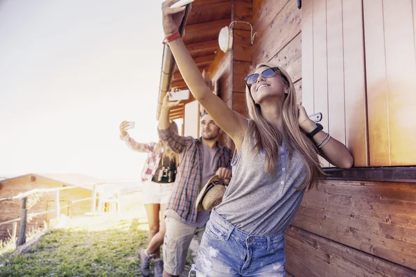 group of smiling friends in single file taking funny selfie with