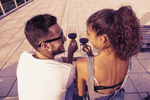 Jeune couple toast sur une terrasse au coucher du soleil — Photo