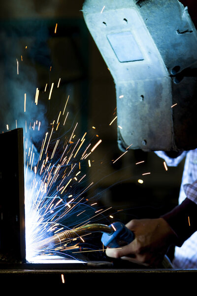 young worker while welding steel