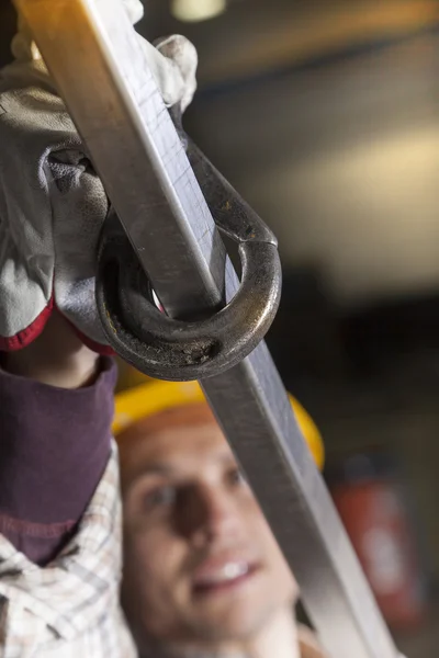 Jovem metalworker ganchos um tubo de aço para levantar — Fotografia de Stock