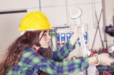 İngiliz anahtarıyla yapan genç kadın metalworker portresi