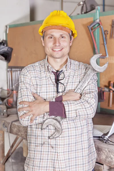 Portrait de jeunes bras de métallurgistes pliés avec clé — Photo