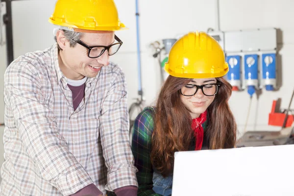 Couple of engineers consult the computer in a steel mill — Stock Photo, Image