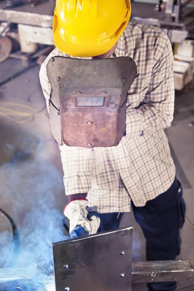 Jovem trabalhador enquanto solda em uma usina de aço — Fotografia de Stock
