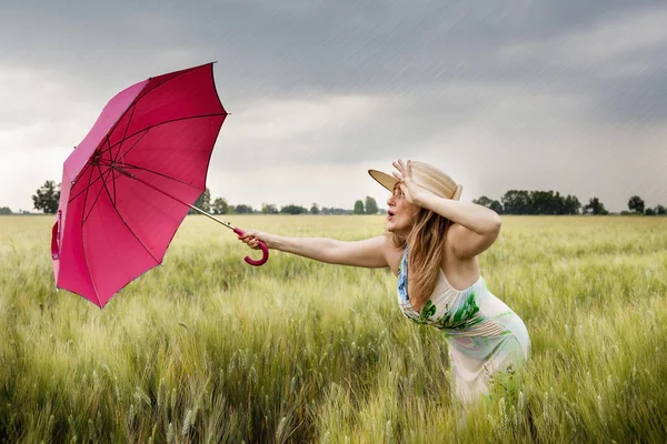 Krásná žena s deštníkem v oblasti uší pšenice — Stock fotografie