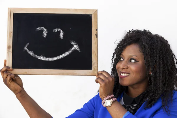 Joven afroamericana chica muestra una pizarra con un dra sonriente —  Fotos de Stock