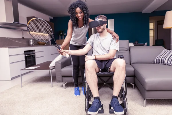 Fiatal lány segíti a fogyatékkal élők, aki játszik a tenisz — Stock Fotó