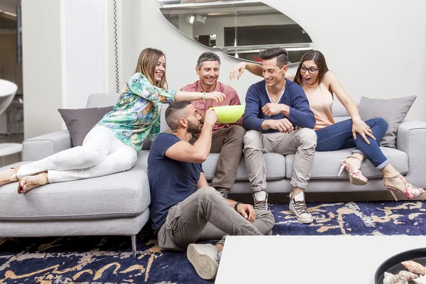 tv izlerken, kanepenin üzerinde patlamış mısır yemek arkadaş grubu