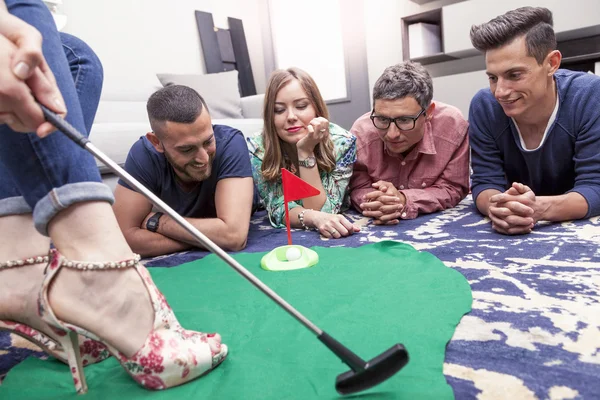 Skupina mladých dospělých bavit, hrát golf v obývacím pokoji — Stock fotografie