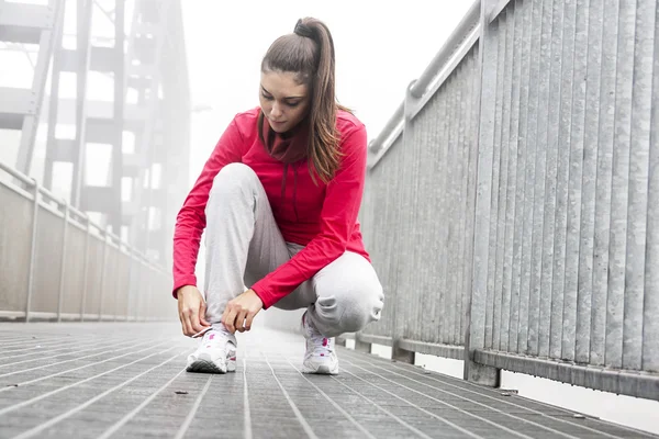 Giovane atleta legandosi le scarpe prima della gara — Foto Stock