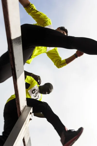 Couple of athletes jumping during obstacle race — Stock Photo, Image