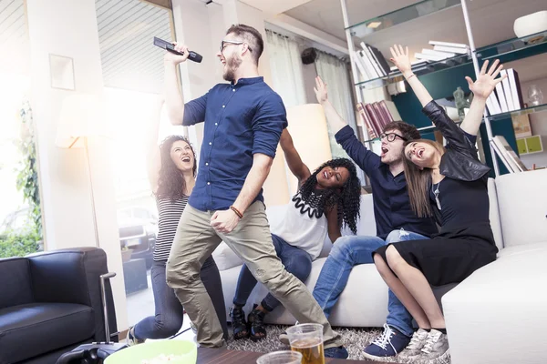 Groep vrienden plezier op thuis zingen een lied samen — Stockfoto