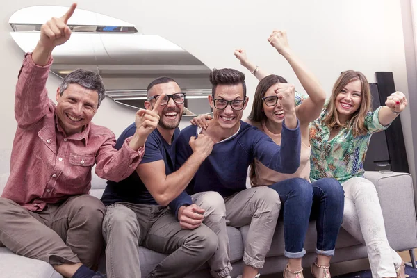 Gruppe von Freunden schaut sich auf der Couch ein Fußballspiel im Fernsehen an — Stockfoto