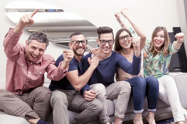 Gruppe von Freunden schaut sich auf der Couch ein Fußballspiel im Fernsehen an — Stockfoto