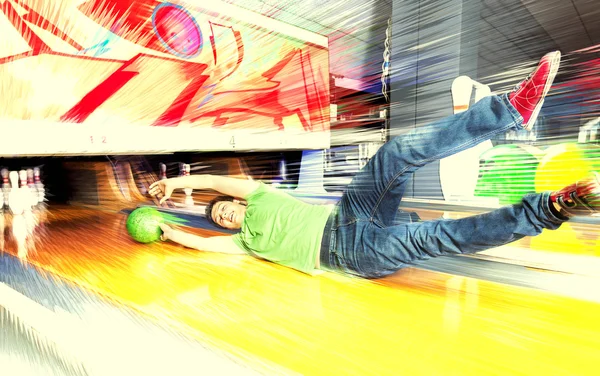 Young man sliding down a bowling alley — Stock Photo, Image