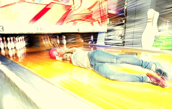 Young woman sliding down a bowling alley — Stock Photo, Image
