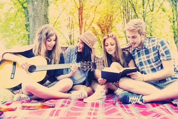 Mladí dospělí bavit se s kytarou na tábořiště — Stock fotografie