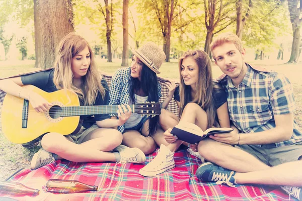 Mladí dospělí bavit se s kytarou na tábořiště — Stock fotografie
