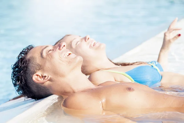 Jeune couple bronzer à la piscine en été — Photo