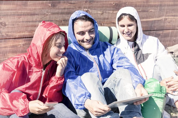 Mladí dospělí naleznete v notebooku na turné v dešti — Stock fotografie