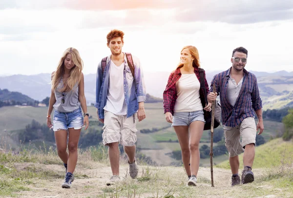 Gruppe junger Wanderer auf dem Weg zum Horizont über den Berg — Stockfoto