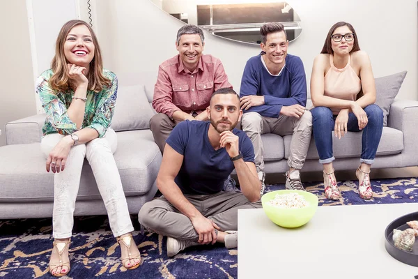 Group of friends watching a football match on tv on the couch — Stock Photo, Image