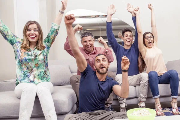 Groep vrienden kijken naar een voetbalwedstrijd op tv op de Bank — Stockfoto