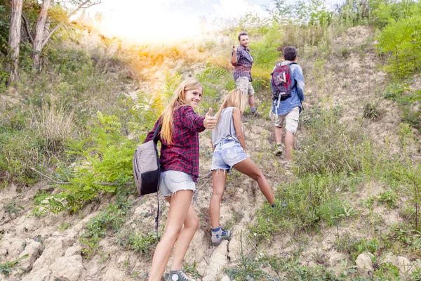 Grupo de jovens caminhantes caminhando em direção ao horizonte sobre a montanha — Fotografia de Stock