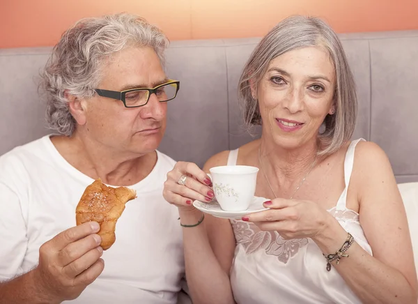Ziemlich ältere Pärchen Spaß im Bett, während Frühstück essen — Stockfoto