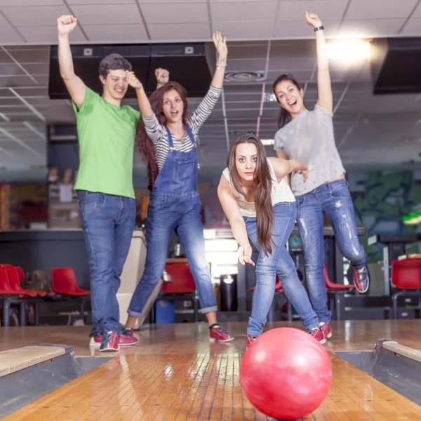 Grupo de adultos jóvenes que se divierten jugando en la bolera — Foto de Stock