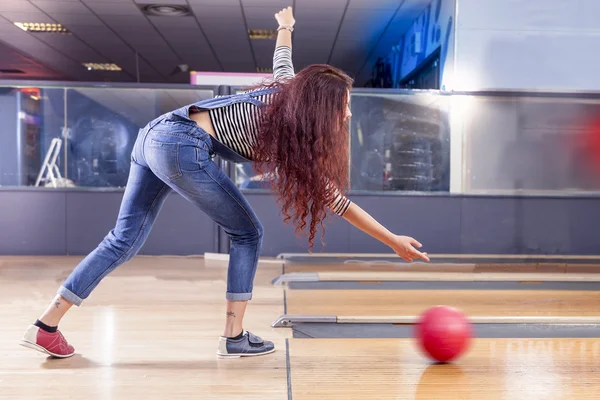 Mladá dívka táhne míč na bowlingu — Stock fotografie