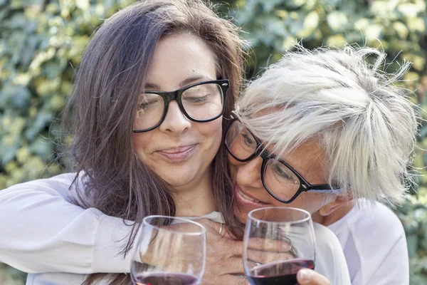 Madre e hija adulta degustación de vino sentado al aire libre —  Fotos de Stock