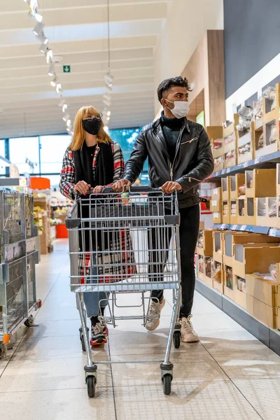 Multietnický Pár Nakupování Supermarketu Obličejovými Maskami Během Pohotovostního Období Koronaviru — Stock fotografie