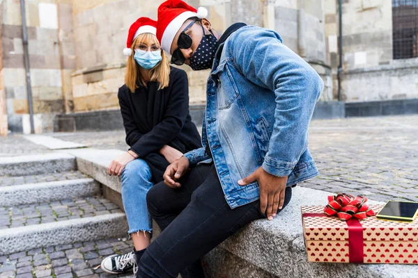 Jovem Casal Multi Étnico Troca Presentes Natal Usando Máscaras Protetoras — Fotografia de Stock