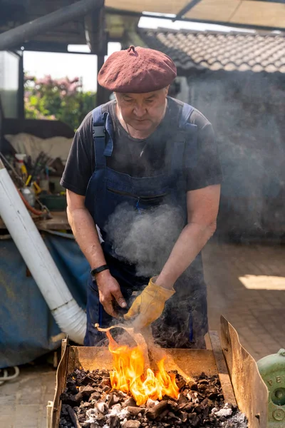 blacksmith is burning a metal bar to give it a new shape. Old work concept