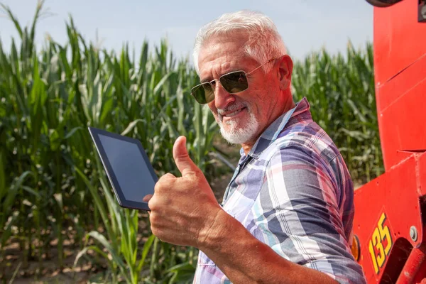 modern technological farmer while checking the growth data of corn on the tablet of his cultivated fields. concept of sustainable exploitation of natural resources.