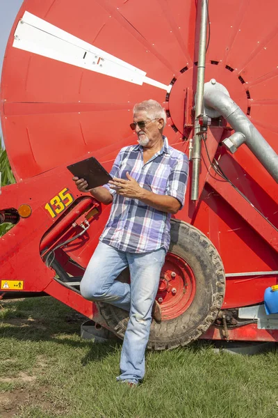modern technological farmer while checking the growth data of corn on the tablet of his cultivated fields. concept of sustainable exploitation of natural resources.
