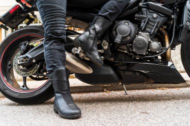 Motosikletli yetişkin bir kadının modern bir motosiklet sürüşünün ayrıntıları.
