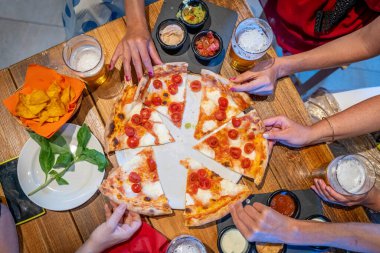 Pizza yiyen kadınlar. Masanın üstünde pizza dilimlerinin yakın plan görüntüsü 